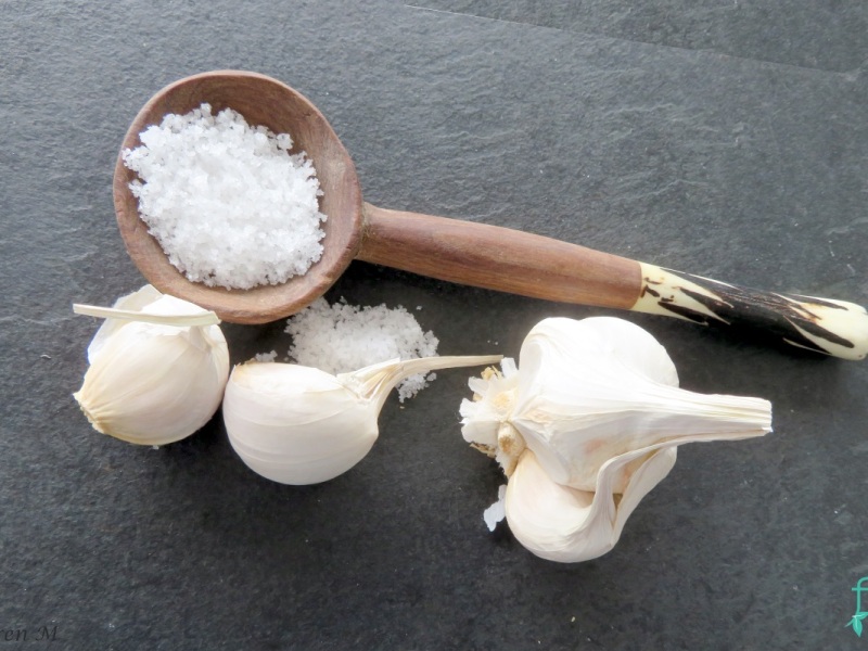 Salt in a wooden spoon with garlic